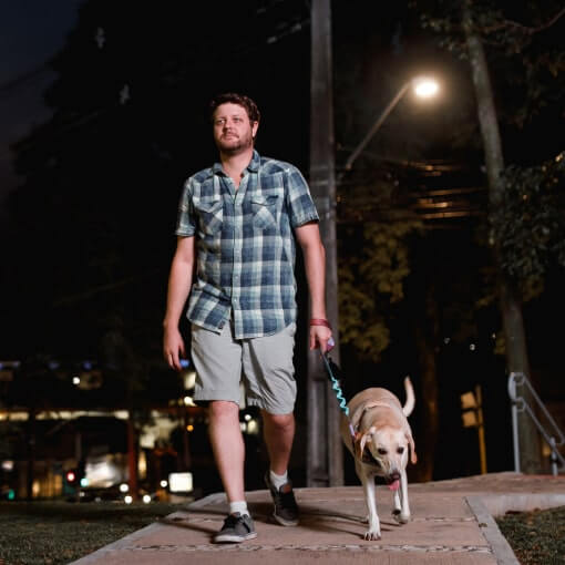 Man walking dog at night